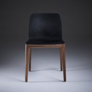 Silla Invito en madera y cuero negro, con acabados suaves y modernos, realizada artesanalmente en Europa