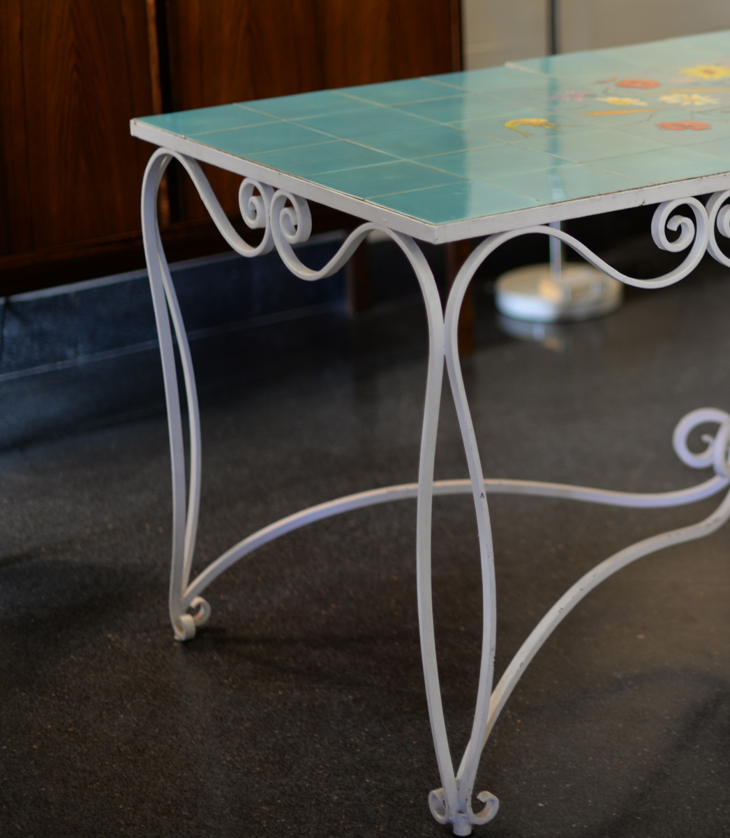 Mesa de hierro forjado y tapa de azulejos con decoración pintada a mano. Detalle