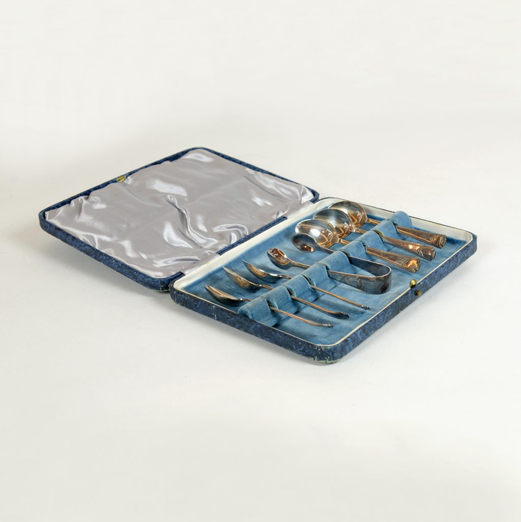 Estuche con doce cucharillas de té y pinza.